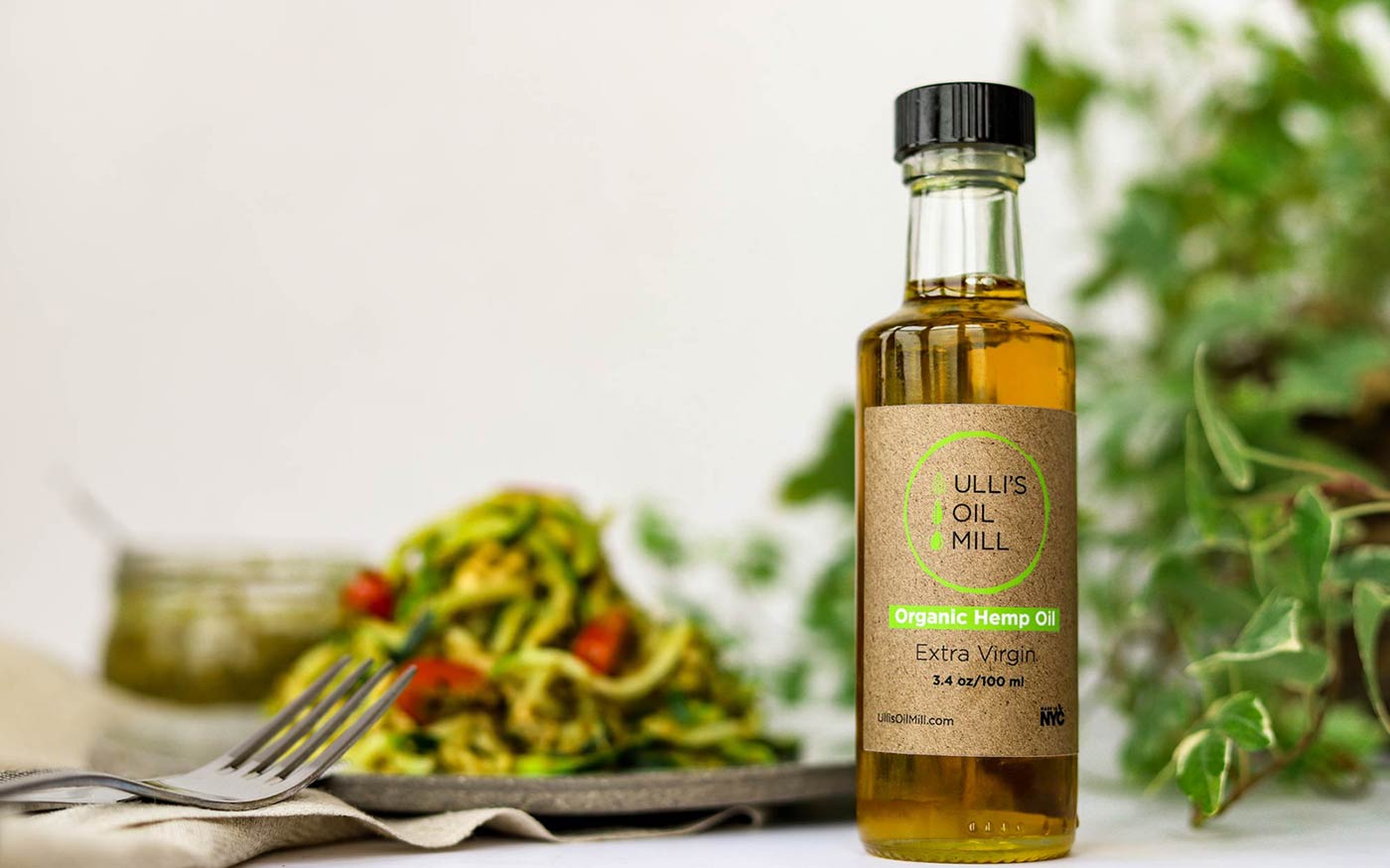 A bottle of Ulli's oil beside a fresh salad